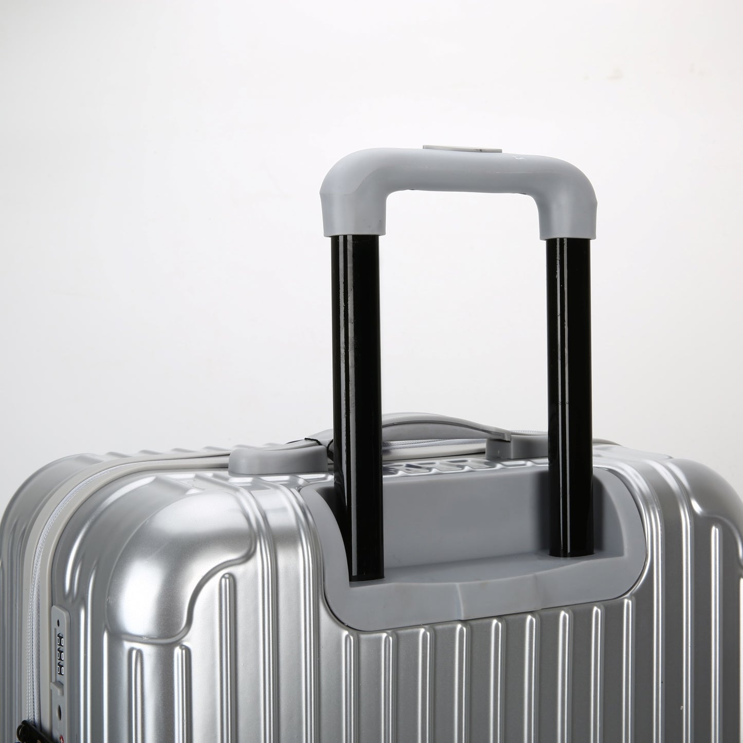 Vista laterale del trolley rigido con evidenza dei 4 piedini laterali gommati di protezione e della maniglia ergonomica laterale.