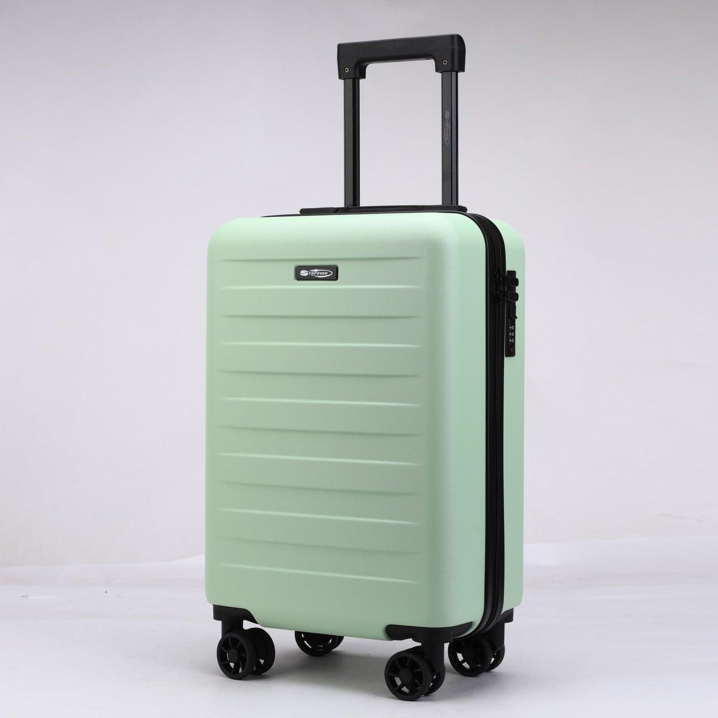 Trolley da cabina verde menta da 54 cm, vista tre quarti con maniglia ergonomica superiore e logo Stopover in metallo